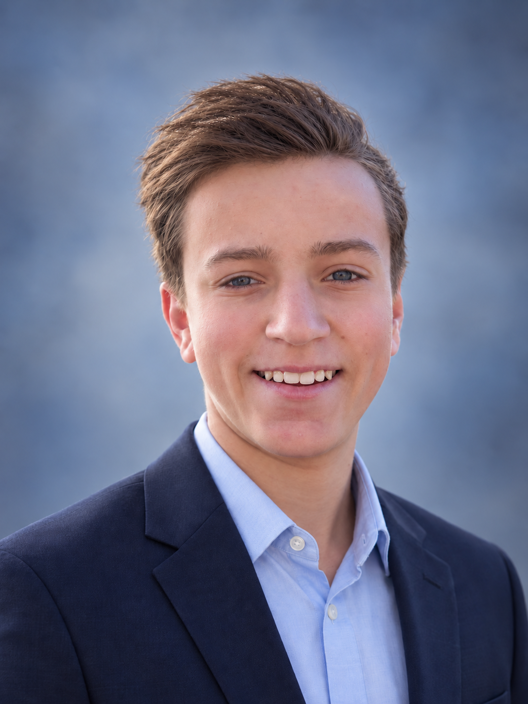 Brady Shaw smiling in a navy blazer and light blue shirt